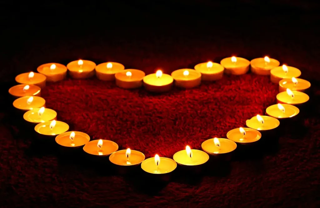 Découvrez cette image émouvante : des bougies disposées en forme de cœur, symbolisant l'amour qui persiste au-delà de l'absence. Explorez la beauté de cette représentation qui transcende la distance physique, évoquant un amour qui brille même dans l'obscurité. 
