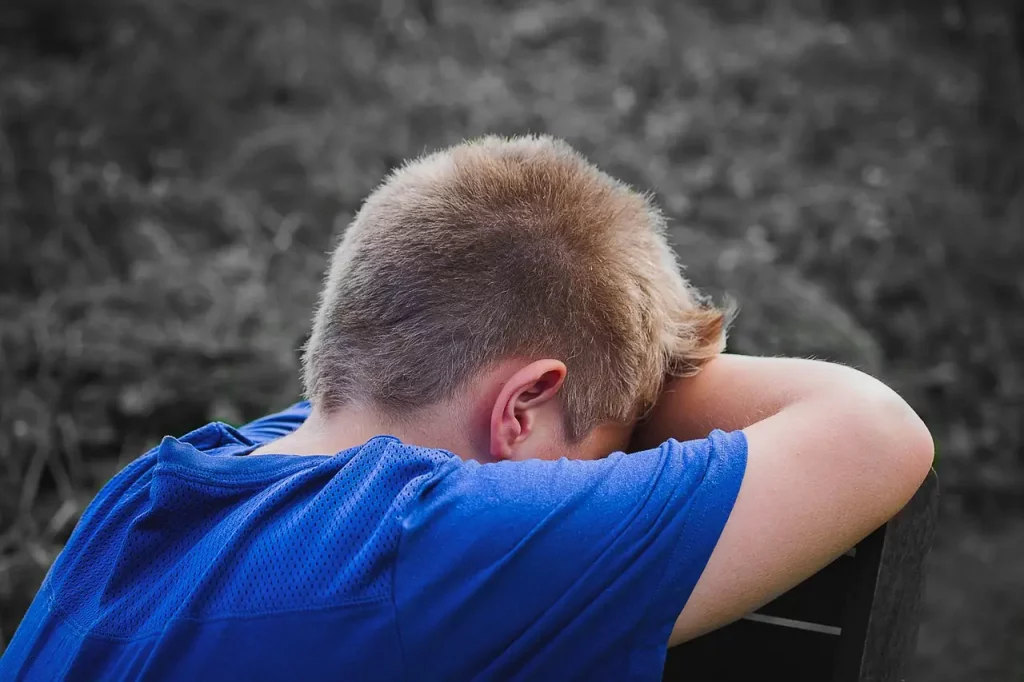Dans cette image poignante, un jeune garçon se tient face au mur, les bras posés contre celui-ci, dans un geste de désespoir palpable. Son corps exprime le poids écrasant du schéma d'imperfection, résultat des expériences traumatisantes de son passé. Les critiques incessantes, les déceptions parentales et les abus ont façonné sa perception de lui-même, le laissant prisonnier de la honte et de la culpabilité. Son visage invisible, tourné loin de nous, reflète la souffrance intérieure qu'il porte, tandis que ses bras étendus symbolisent son isolement et son impuissance face à ces sentiments douloureux. Cette image invite à une profonde réflexion sur les origines profondes du schéma d'imperfection et sur la nécessité de briser ce cycle de souffrance pour embrasser une vie d'authenticité et de guérison.