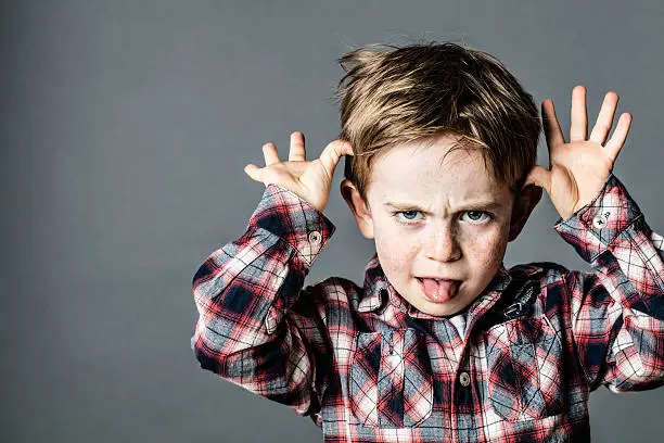 Découvrez l'attitude frondeuse et capricieuse illustrant le Schéma 'Tout Nous Est Dû'. Dans cette image, un petit garçon fait une grimace en tirant la langue et en plaçant ses mains de chaque côté de sa tête. Cette expression reflète le sentiment de privilège et de caprice associé à ce schéma psychologique. Explorez comment cette attitude peut influencer nos comportements et nos interactions, et apprenez à reconnaître et à surmonter ses effets pour une vie plus équilibrée et harmonieuse.